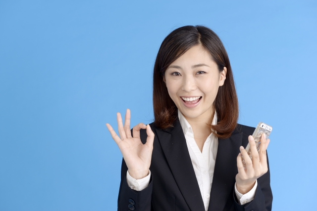 OKマークをつくるスーツの女性