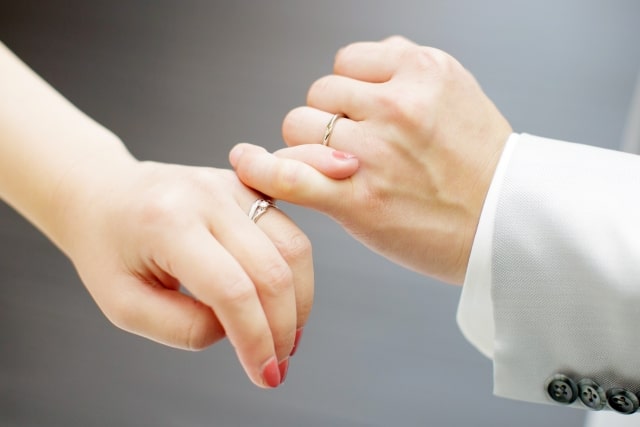 結婚指輪をつけて指切りする新婚夫婦