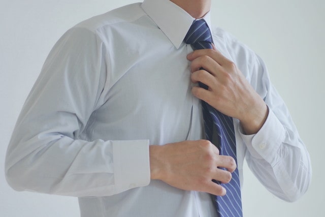 ネクタイを結ぶ男性